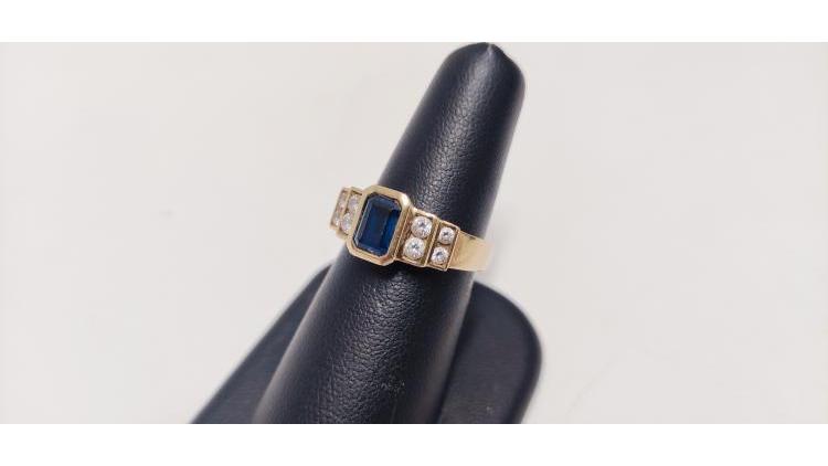 Anello con pietra blu centrale e bianche laterali.